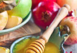 Pomegranate, apple and honey, traditional food of jewish New Year celebration, Rosh Hashana. Selective focus.