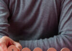 Front view of a man making a Sorry sign spelled on wooden cut circles.