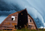 tornado forming behind old barn on american plains