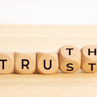 Truth or trust concept. Text on wooden blocks. White background. Copy space